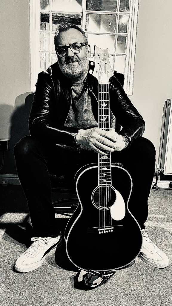Lee Macey with an acoustic guitar